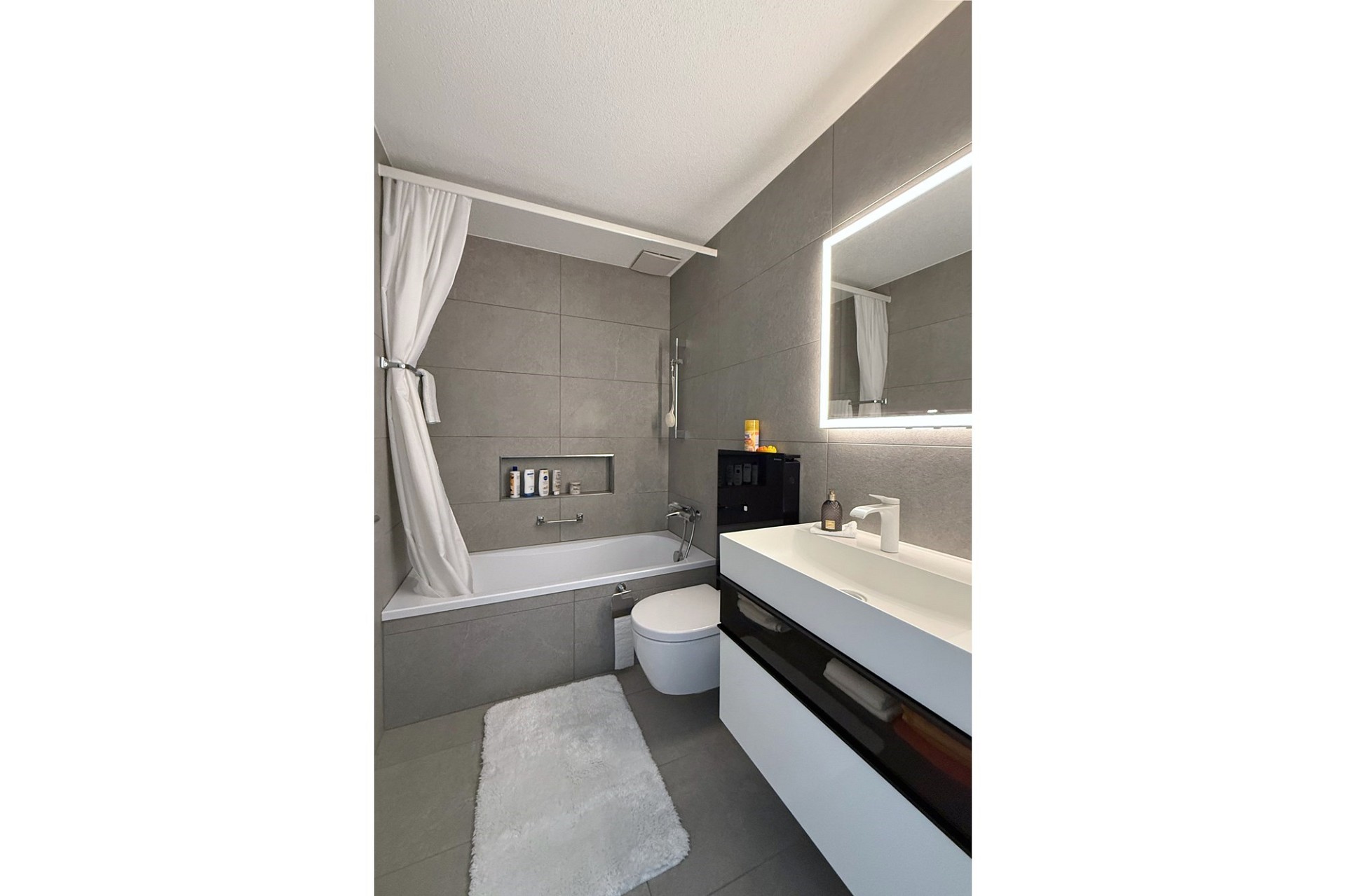 Modernes Bad mit Wanne und beleuchtetem Spiegel