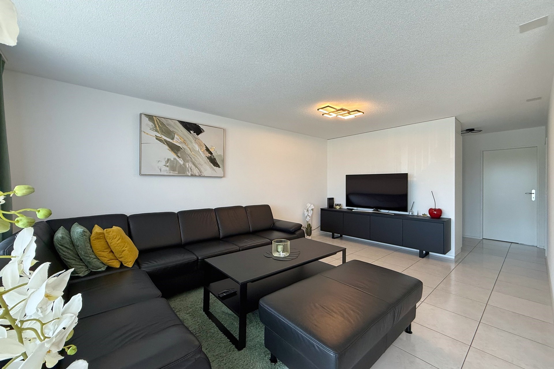 Modernes Wohnzimmer mit Ecksofa und TV-Wand