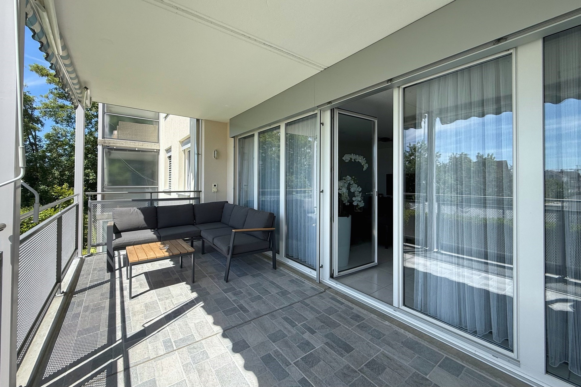 Überdachter Balkon mit Sitzgruppe