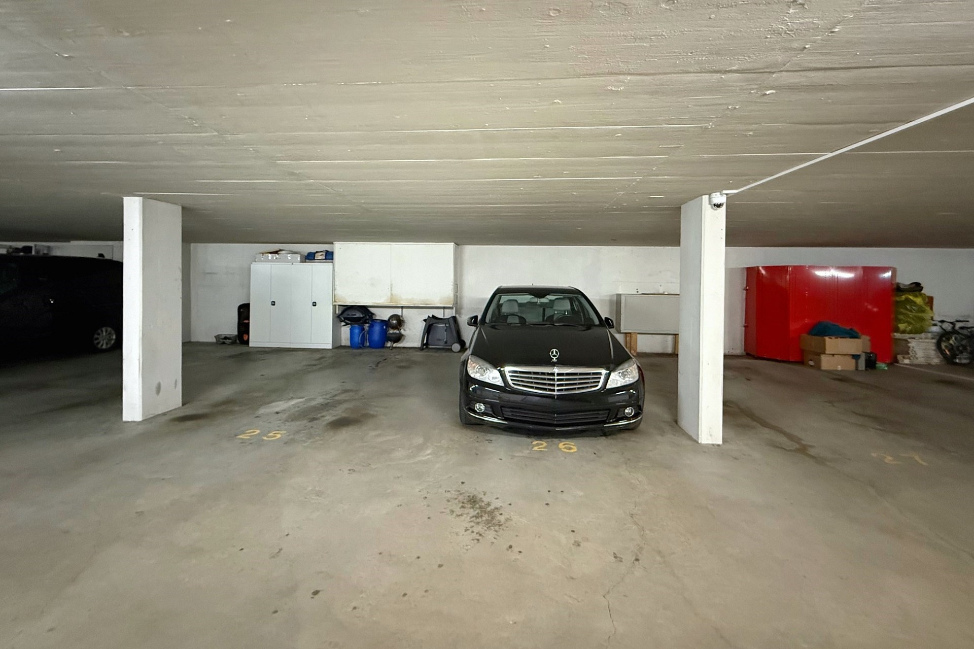 Tiefgarage mit geparktem Fahrzeug und Lagereinrichtungen