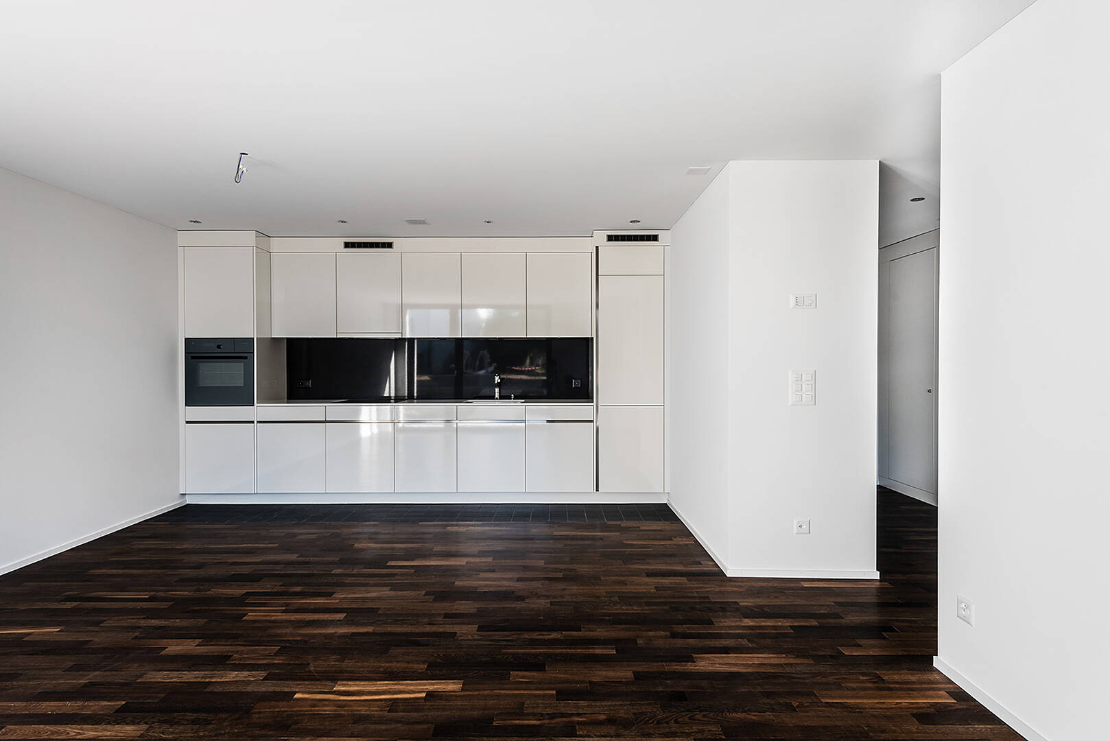 Moderne offene Küche mit dunklem Holzboden