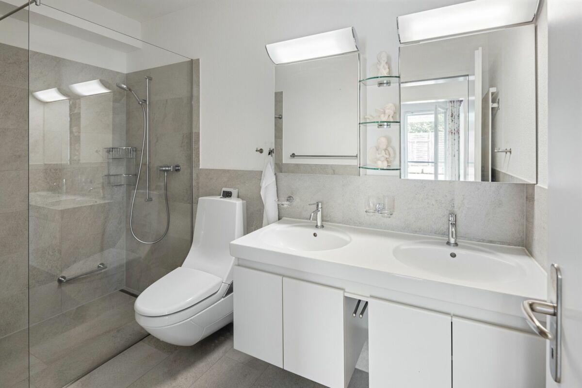 Modernes Badezimmer mit Doppelwaschtisch und Glasdusche