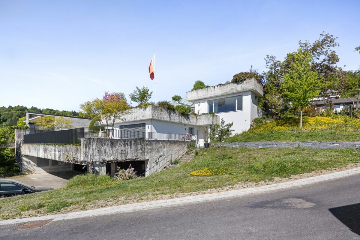 Modernes Hanghaus mit begrüntem Dach und Garage