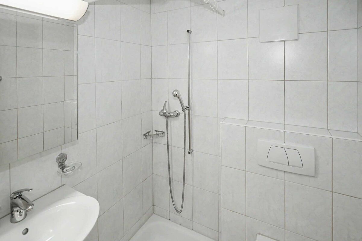 Kleines weiß gefliestes Badezimmer