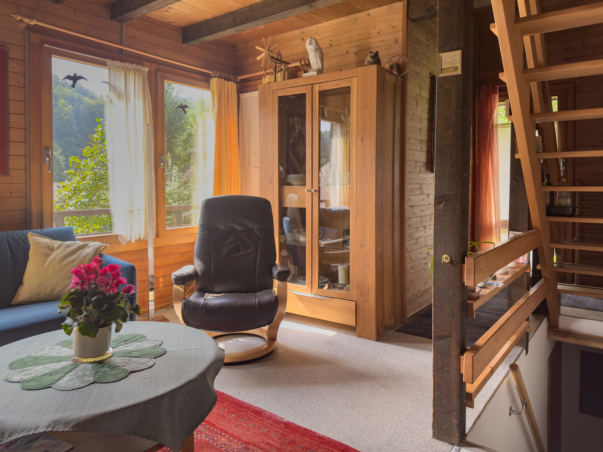 Gemütlicher, holzverkleideter Wohnbereich mit Galerie