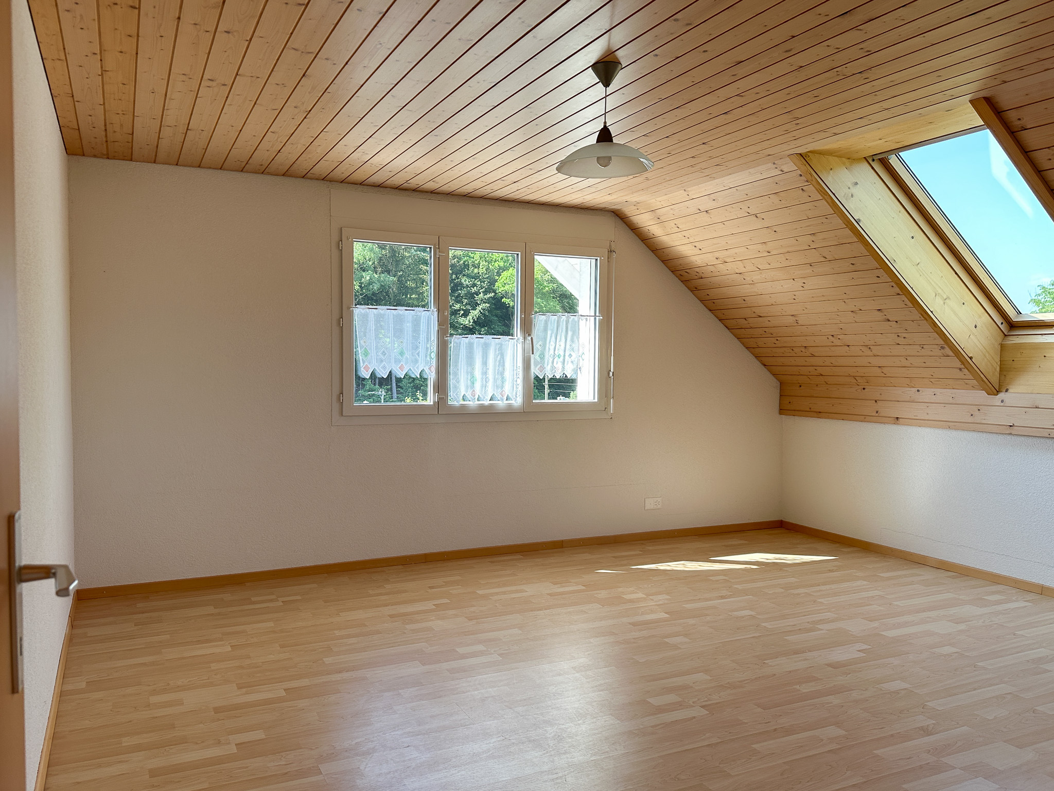 Helles Dachzimmer mit Holzdecke