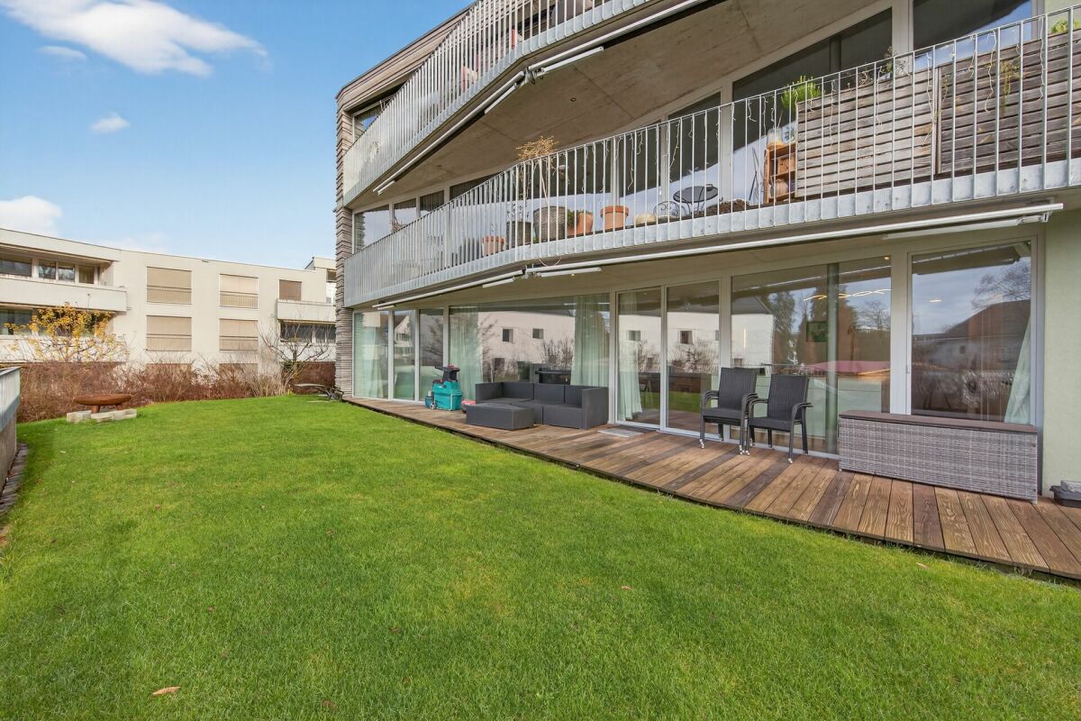 Außenansicht mit Garten und Balkon eines modernen Mehrfamilienhauses
