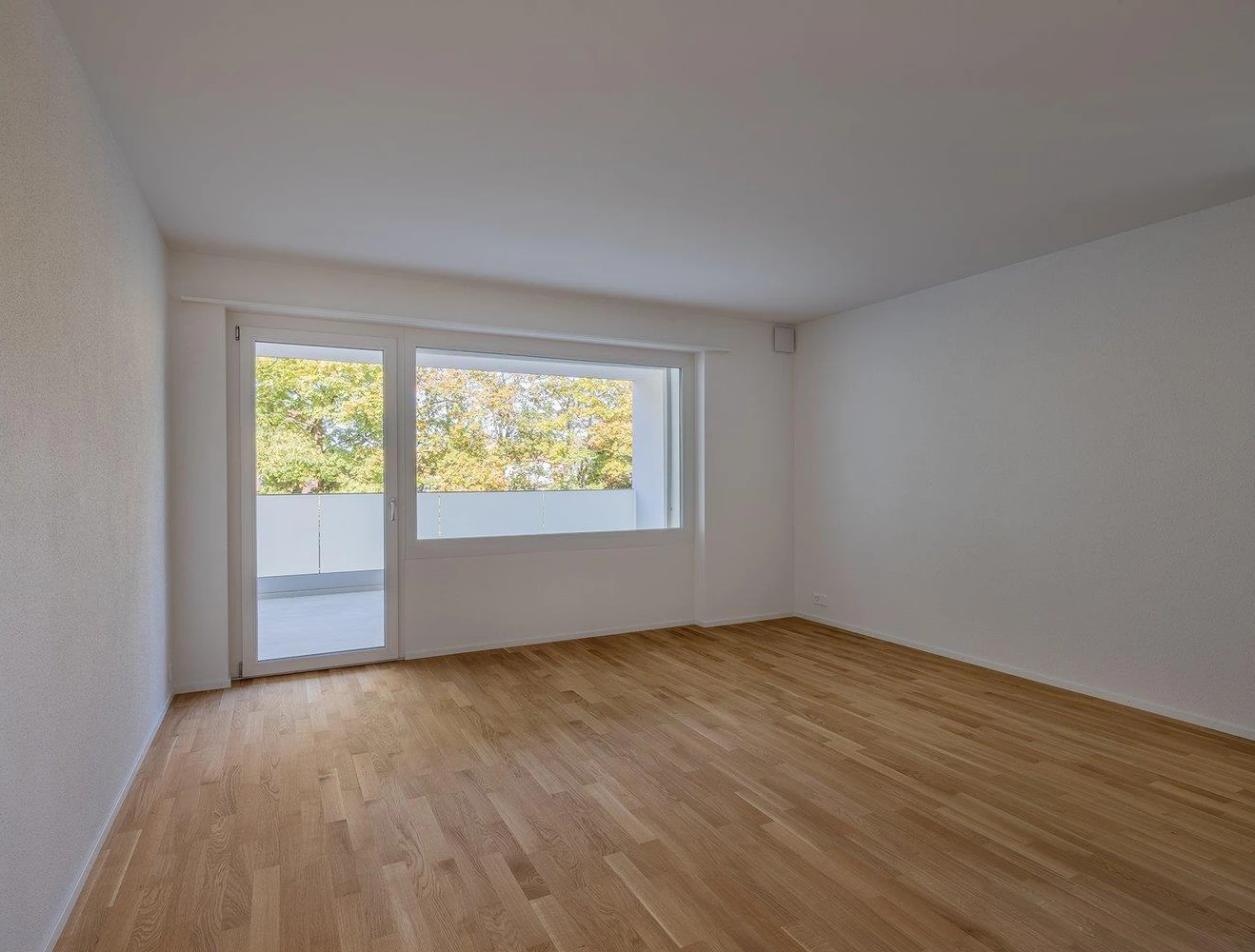 Leerer Wohnraum mit Balkonzugang