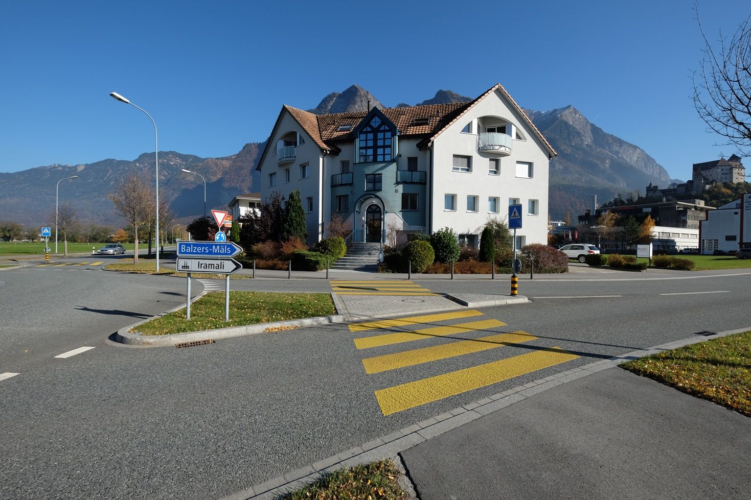 Wohnhaus an Straßenkreuzung mit Bergkulisse