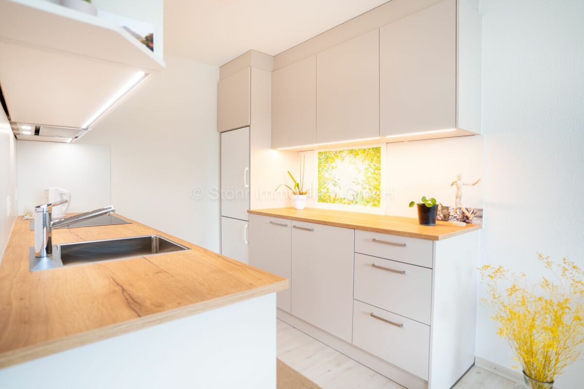 Moderne, helle Küche mit Holzarbeitsplatte