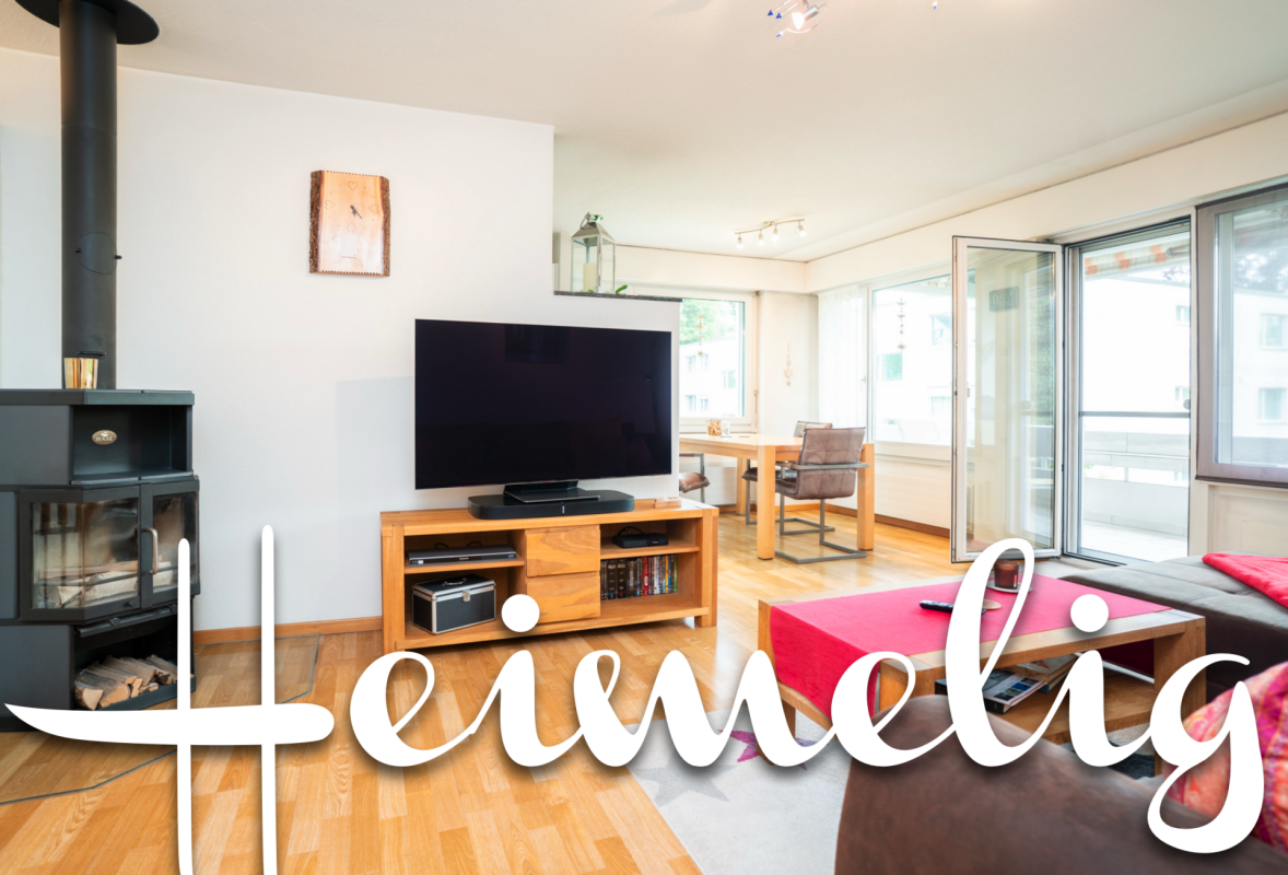 Helles Wohnzimmer mit Kaminofen und Fensterfront
