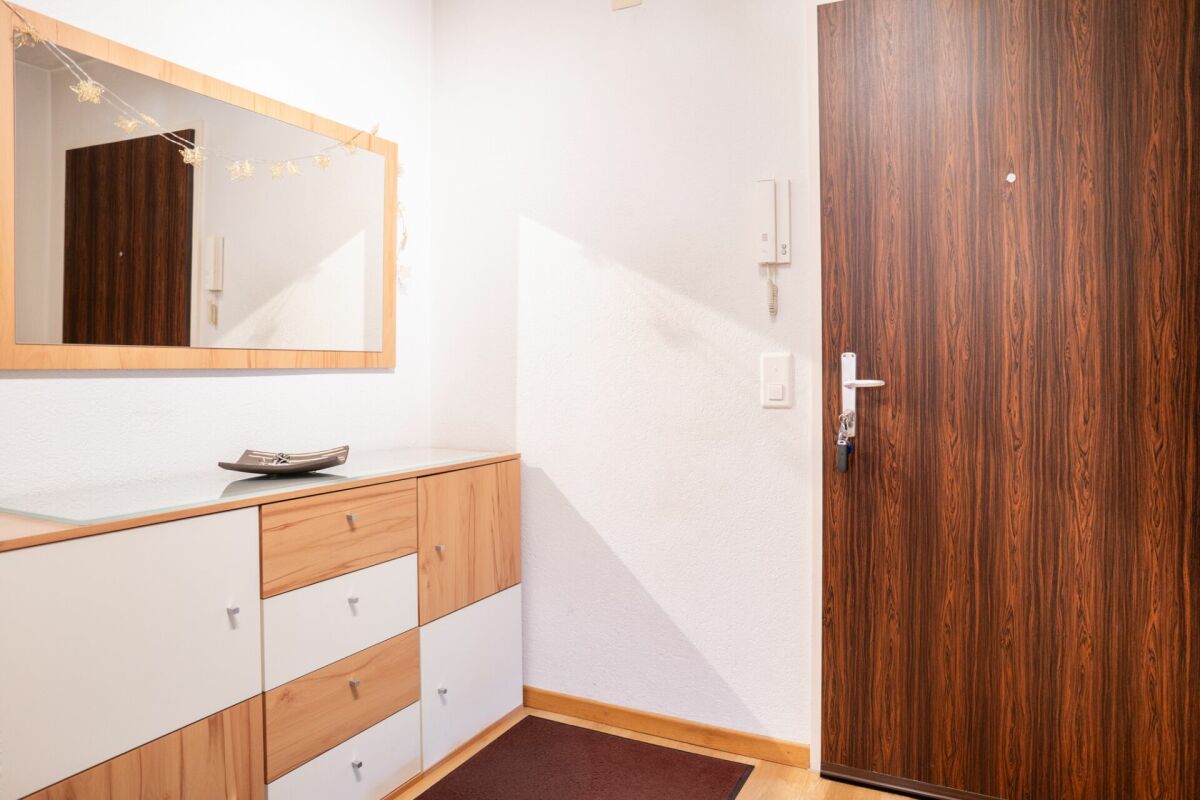 Eingangsbereich mit Kommode und Holztür