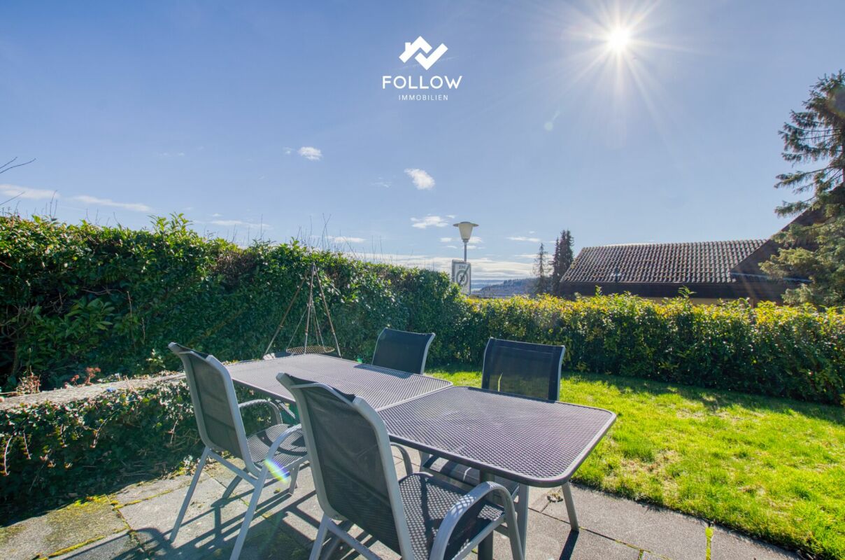 Terrasse mit Gartenmöbeln im Sonnenlicht