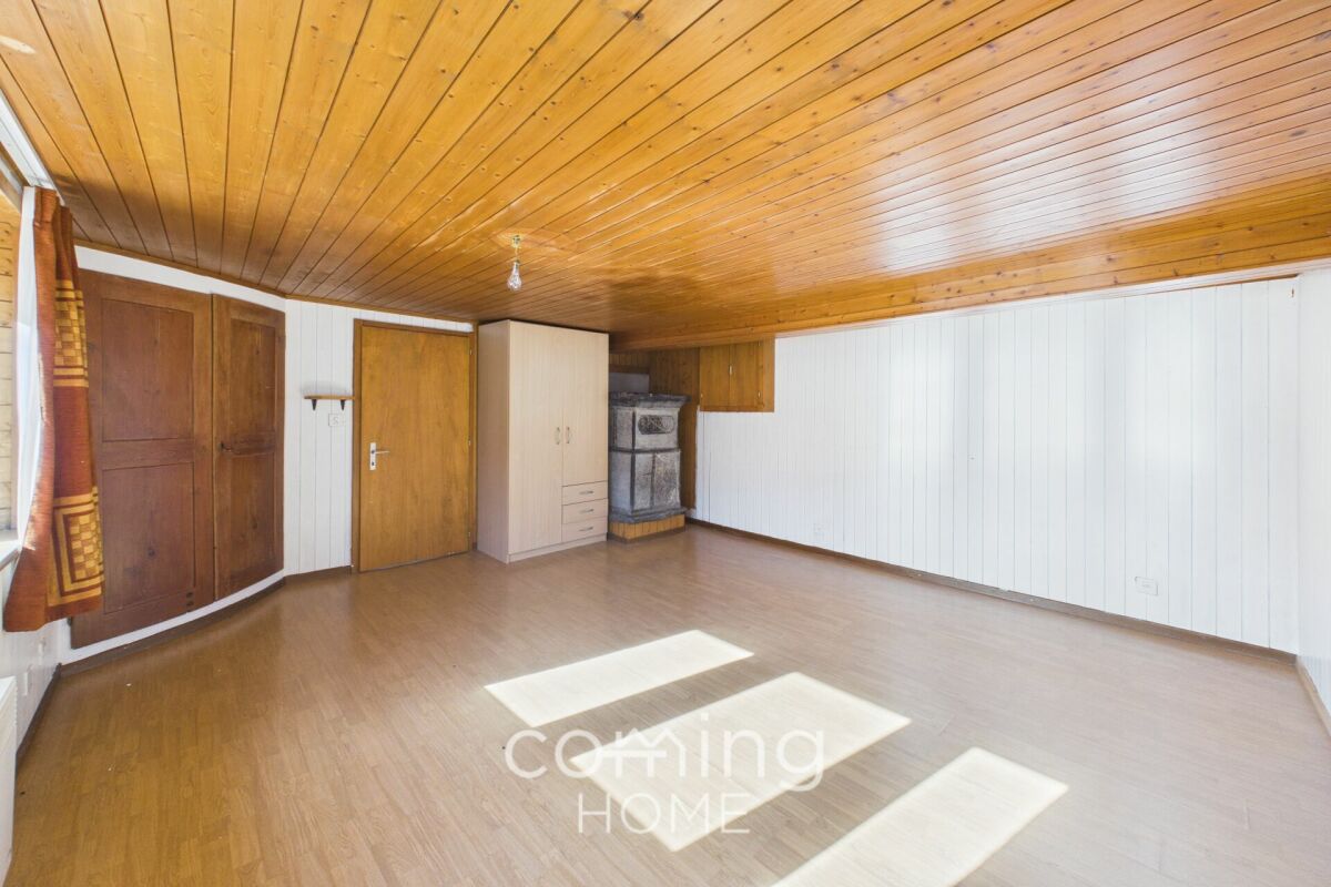 Großer leerer Raum mit Holzdecke und Kamin
