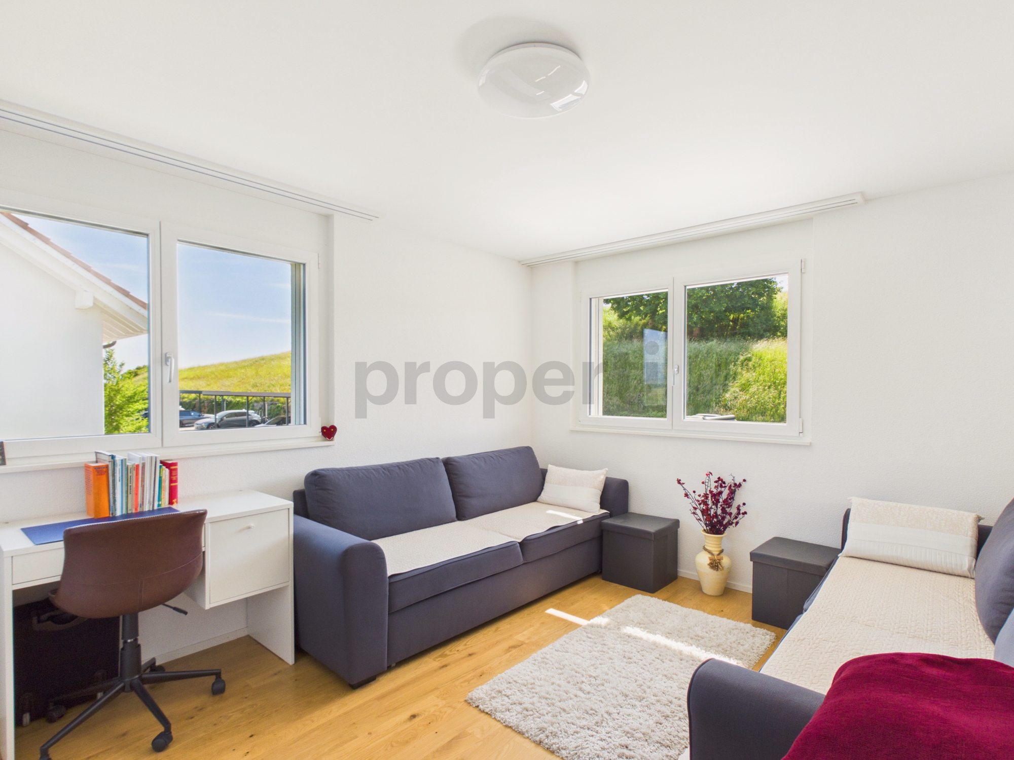 Helles Schlafzimmer mit Arbeitsplatz und Gartenblick