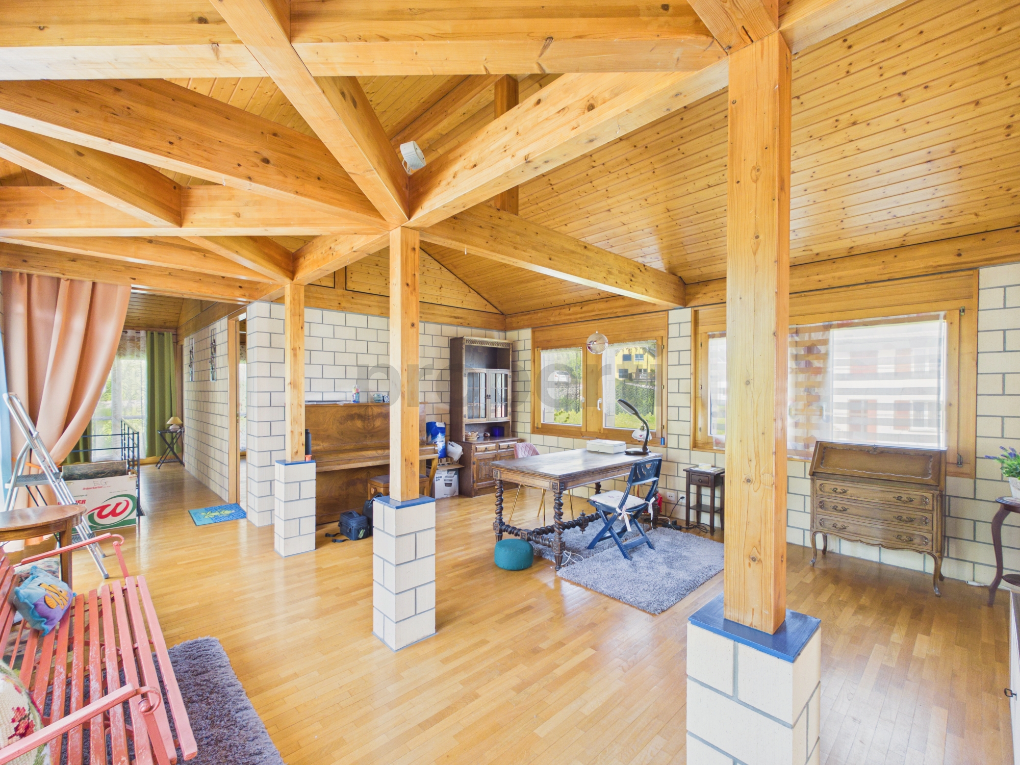 Holzverkleideter Wohnraum mit sichtbaren Balken