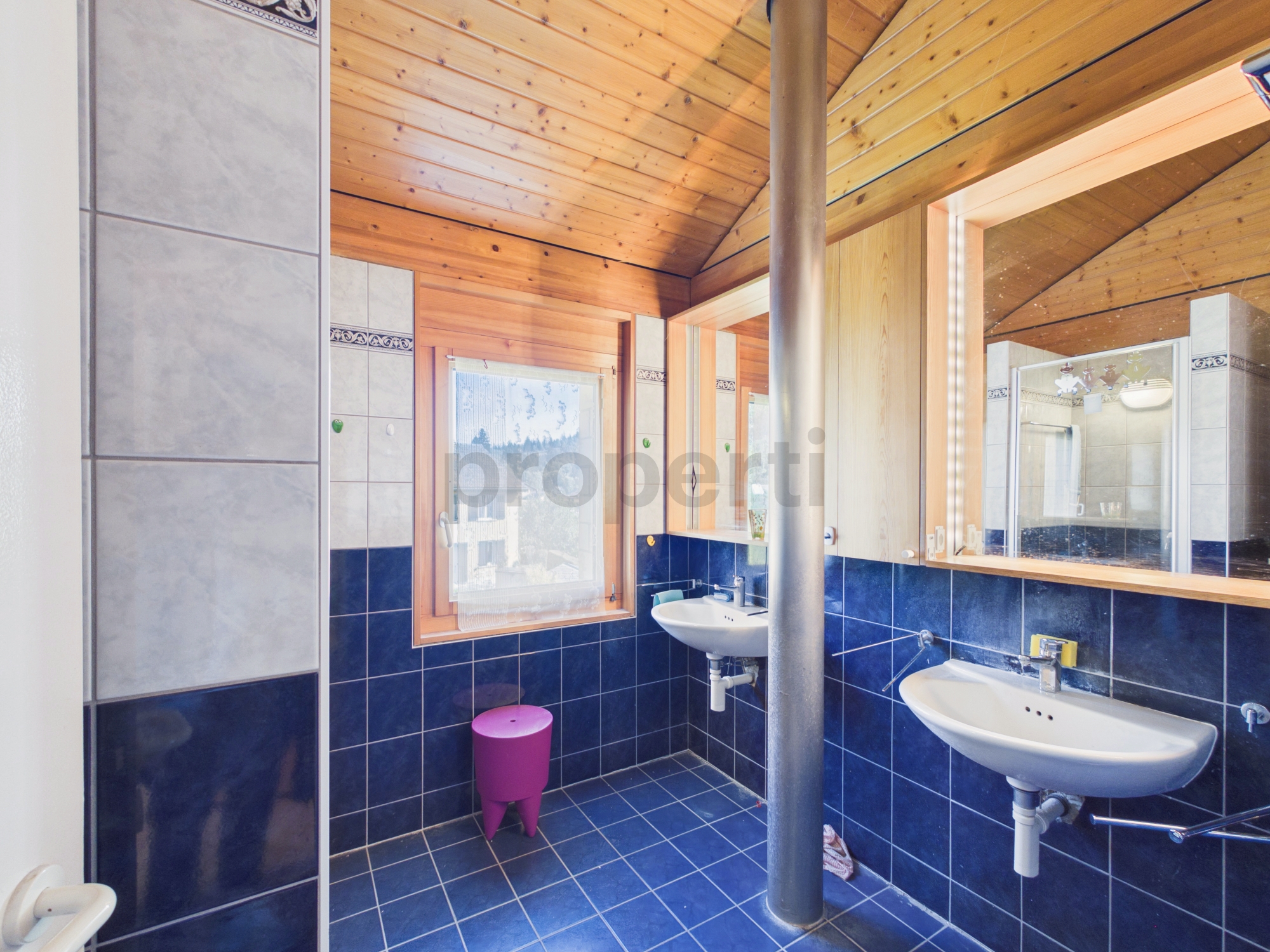 Badezimmer mit Holzdecke und blauen Fliesen