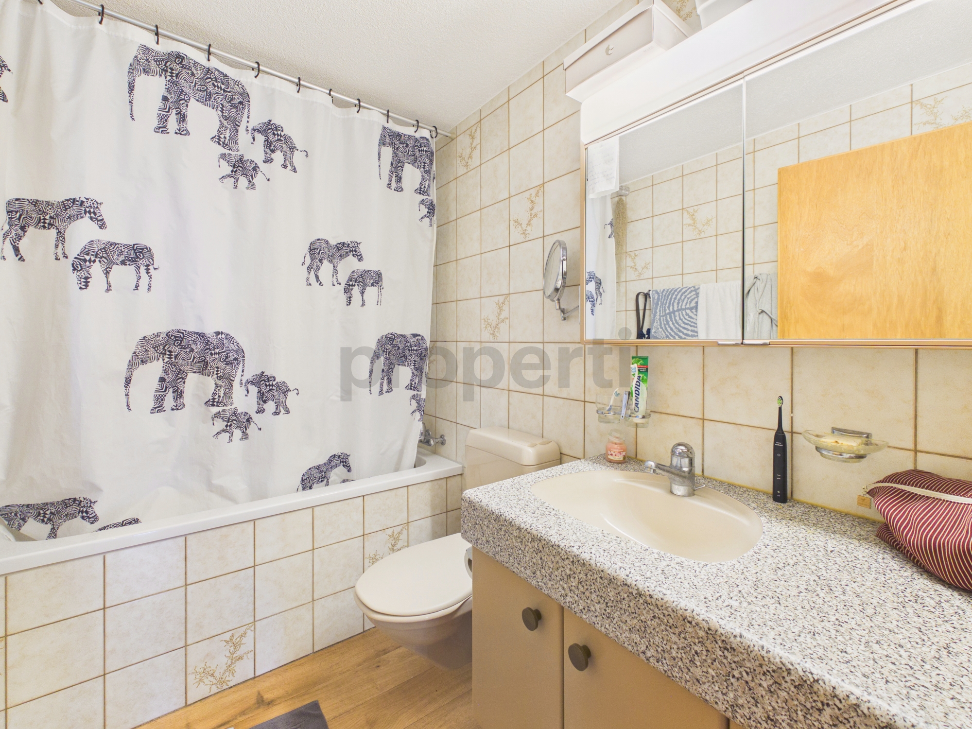 Badezimmer mit Badewanne, Waschbecken und Spiegelschrank