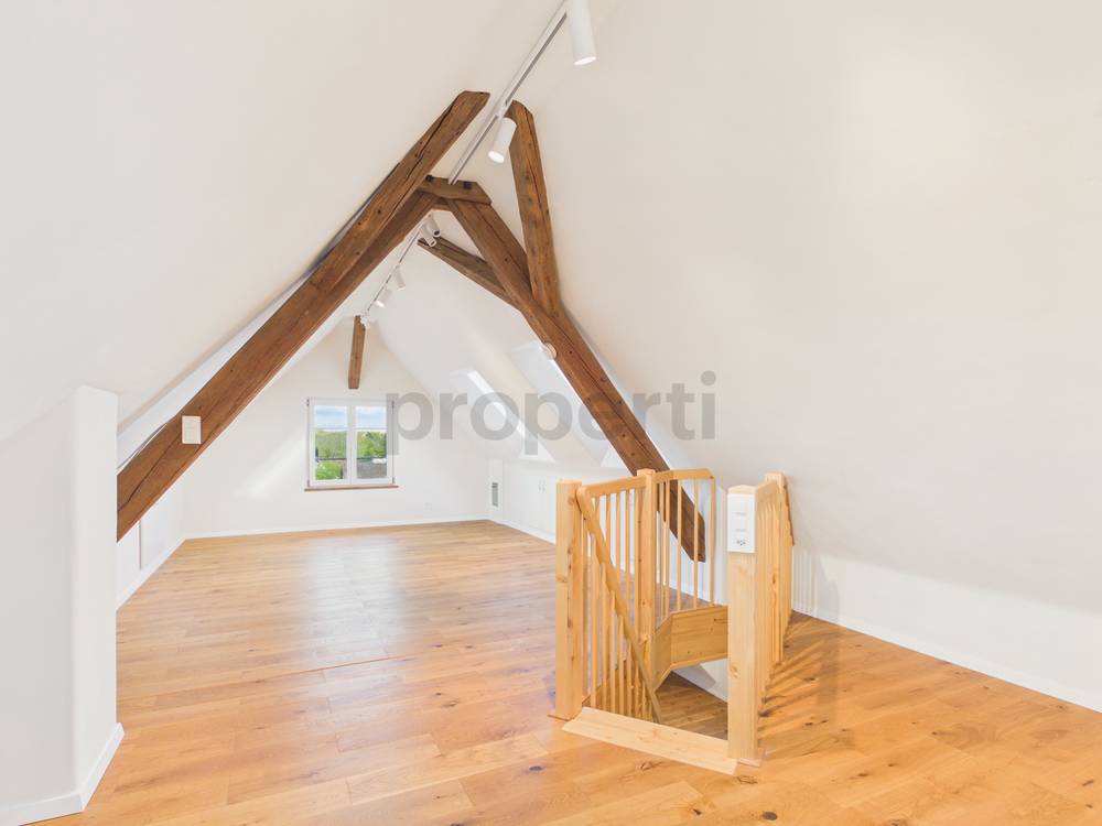 Heller Dachgeschossraum mit sichtbaren Holzbalken