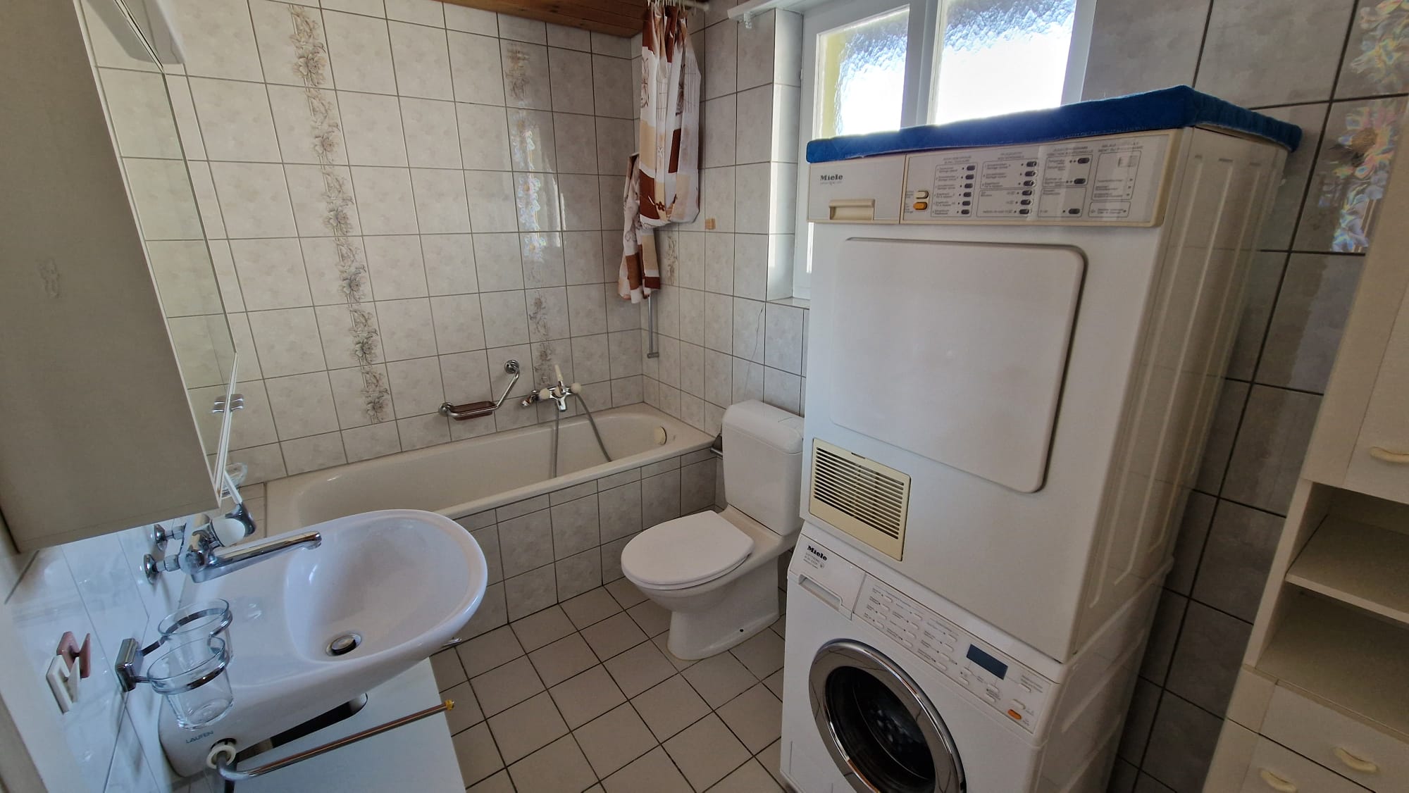 Kleines Bad mit Badewanne und Waschmaschine