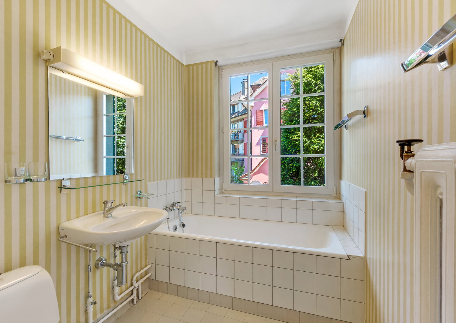 Kleines Badezimmer mit Badewanne und Fensterblick