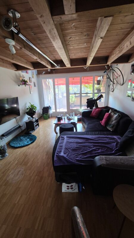 Wohnzimmer mit freigelegten Holzbalken