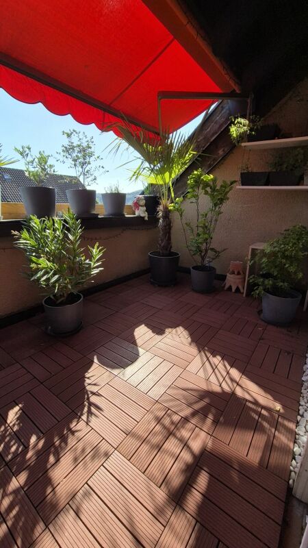 Balkon mit roten Markisen und Topfpflanzen
