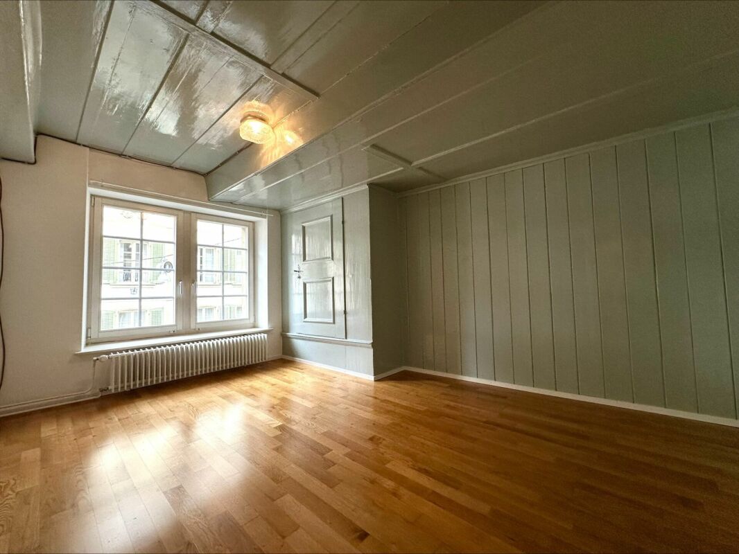 Heller leerer Raum mit Holzboden und Fenster
