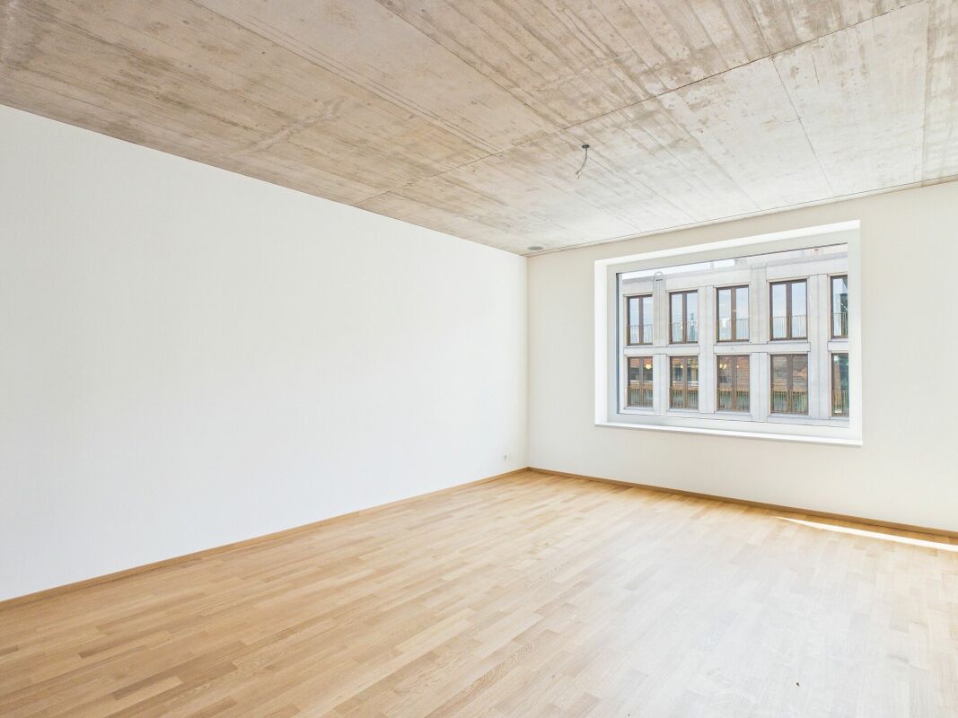 Leerer moderner Raum mit Sichtbetondecke und großem Fenster