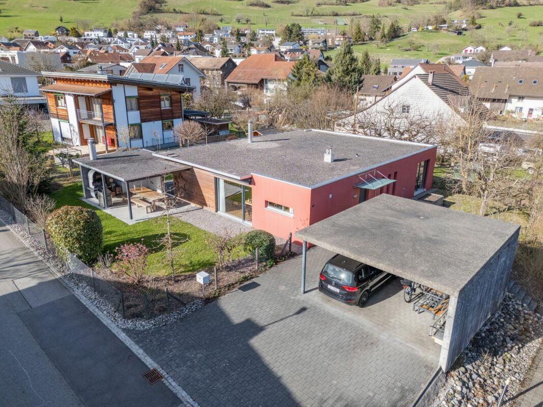 Moderne Hausansicht mit Carport und Garten