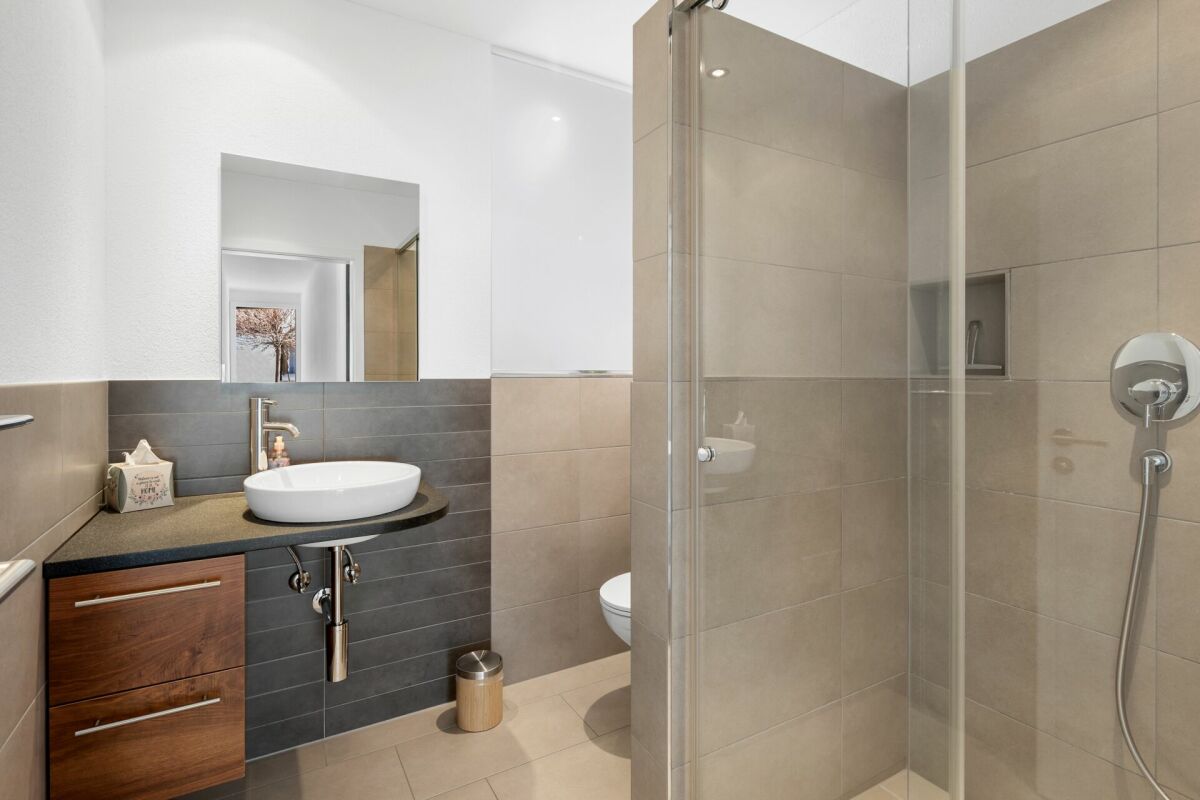 Modernes Badezimmer mit Dusche und Waschtisch