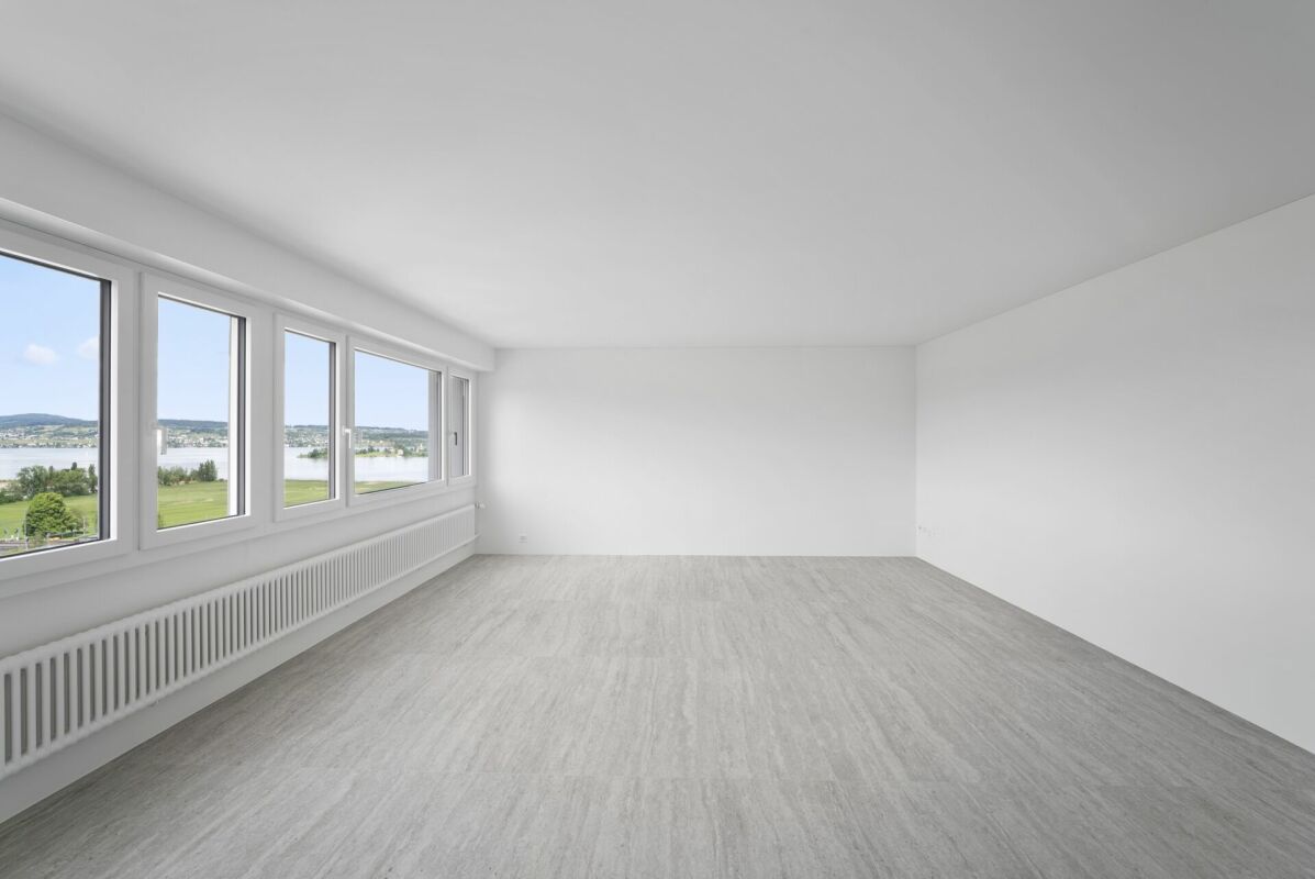 Heller leerer Raum mit Panoramafenstern und Blick auf Wasser