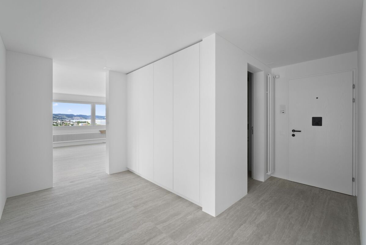 Heller Eingangsbereich mit Blick in einen Wohnraum und Wasserblick