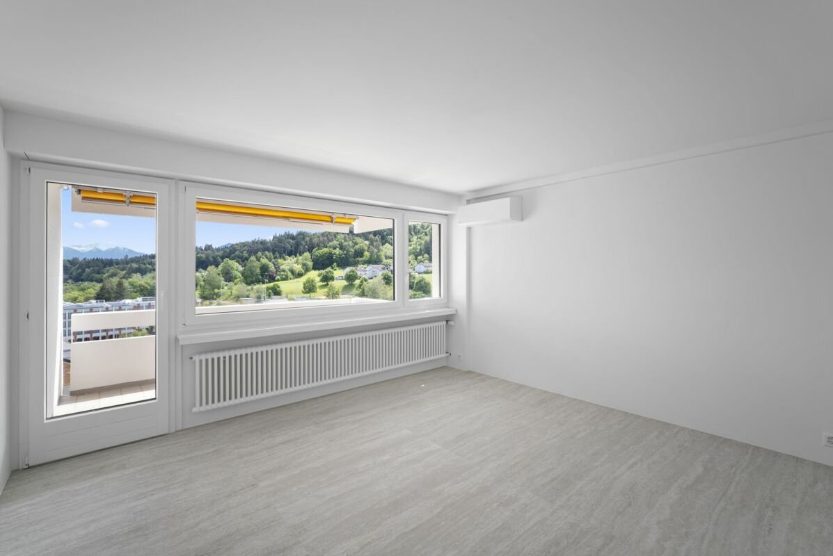 Helles, leer geräumtes Zimmer mit Balkon und Weitblick