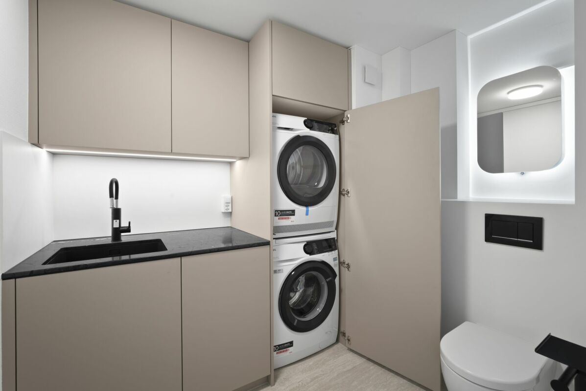 Modernes Gäste-WC mit integriertem Waschtisch und Waschmaschinen-Schrank