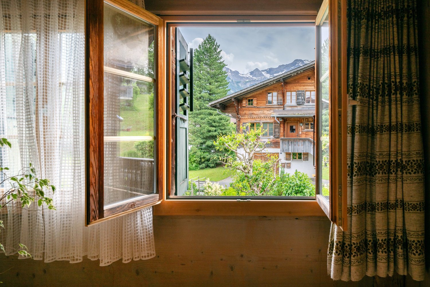 Fensterblick in ein alpines Holzhaus