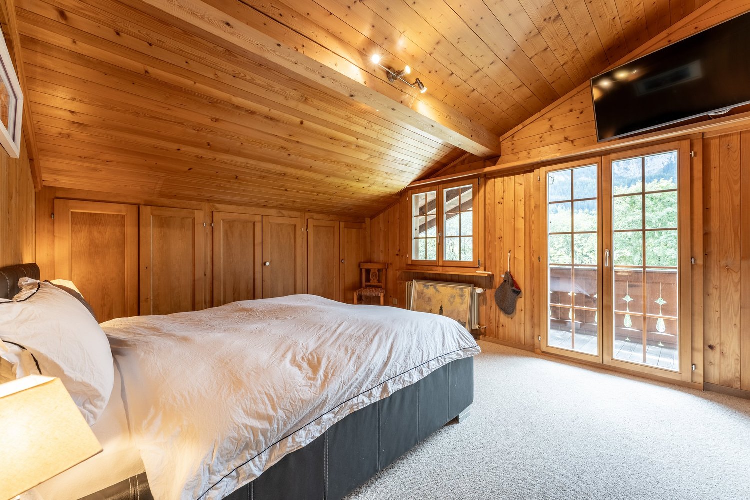 Gemütliches Holzschlafzimmer mit Balkonblick