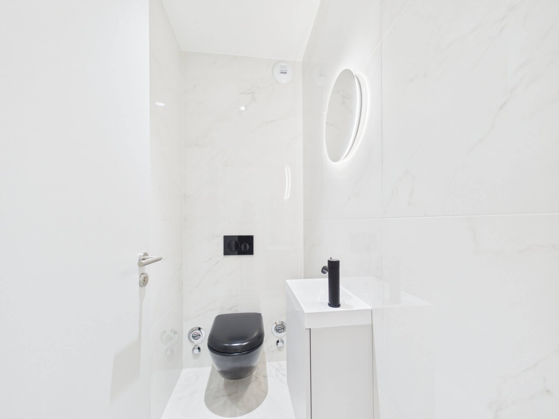 Modernes Gäste-WC mit dunkler Wandtoilette