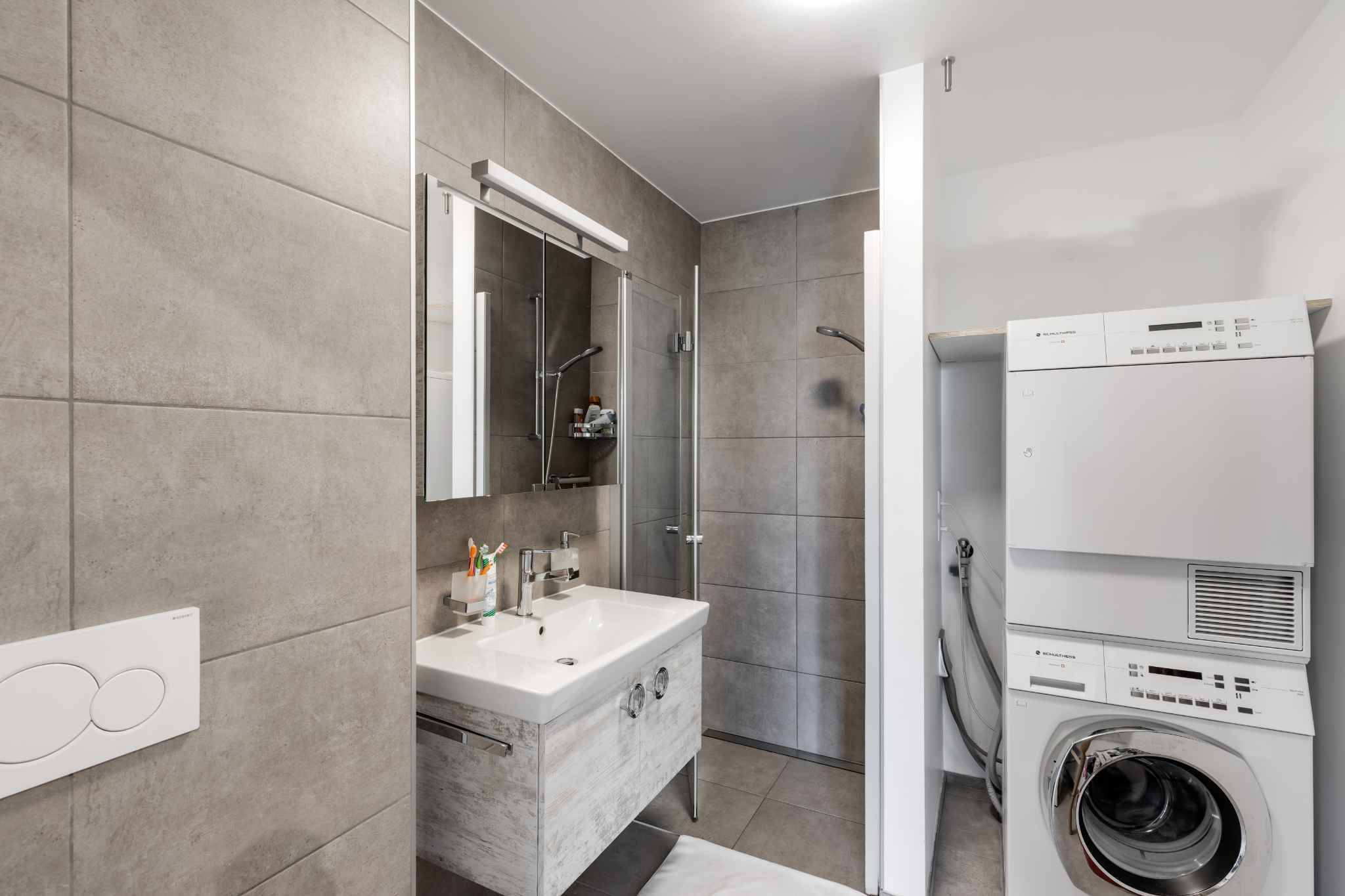 Modernes Badezimmer mit Dusche und Hauswirtschaftsbereich