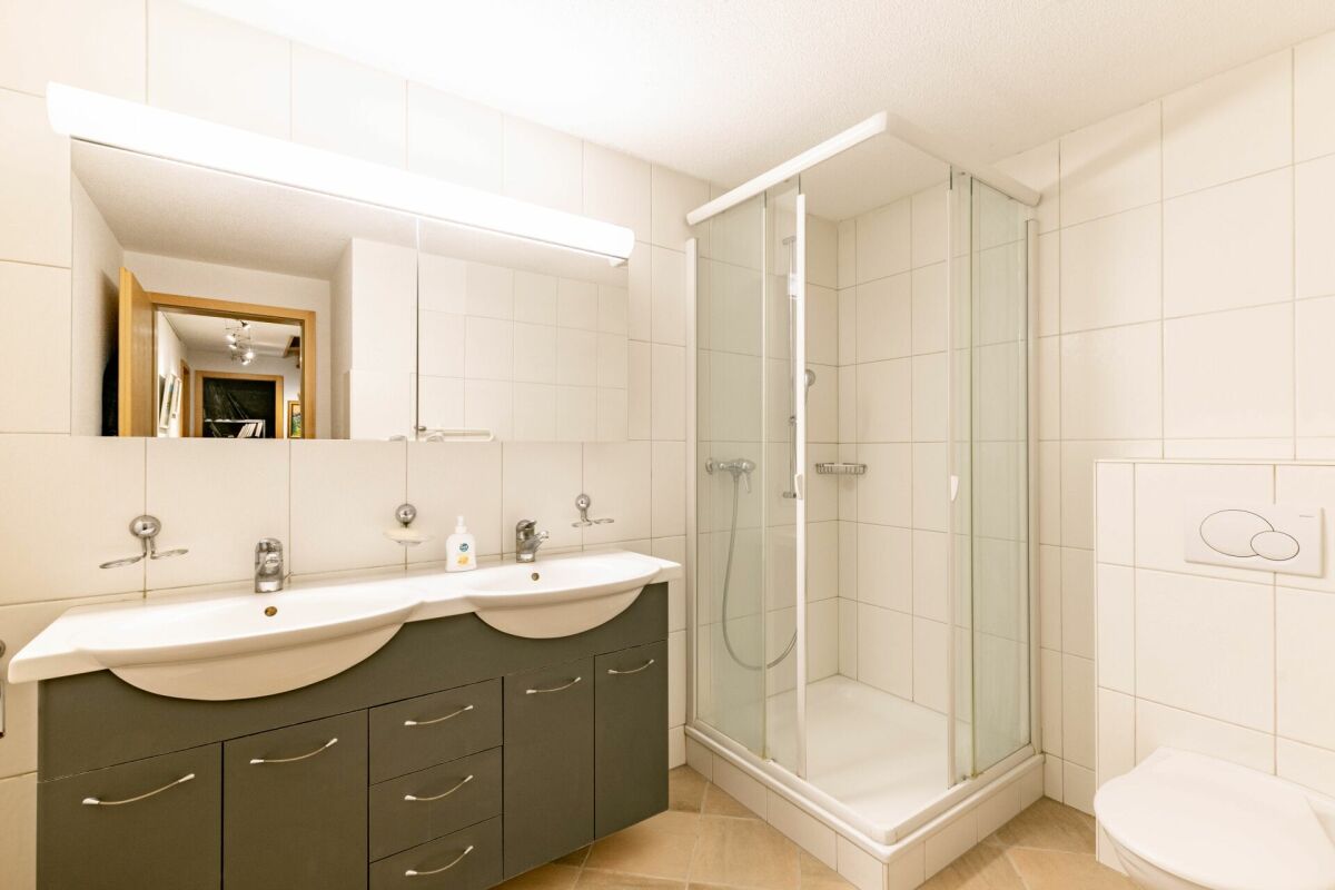 Modernes Badezimmer mit Doppelwaschbecken und Dusche