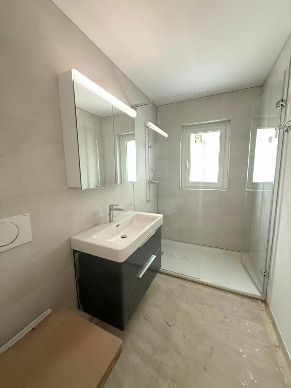 Modernes Badezimmer mit Dusche und Waschtisch
