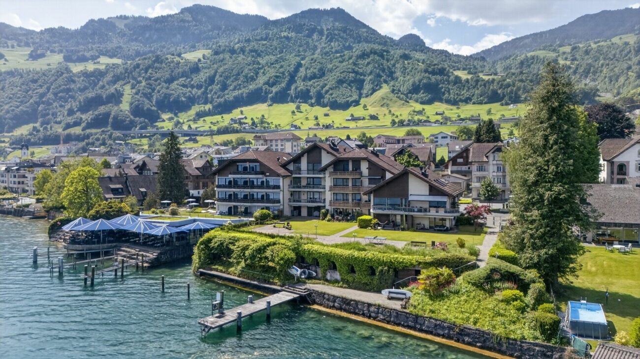Seeufer-Ort mit Wohnhäusern und Bergpanorama