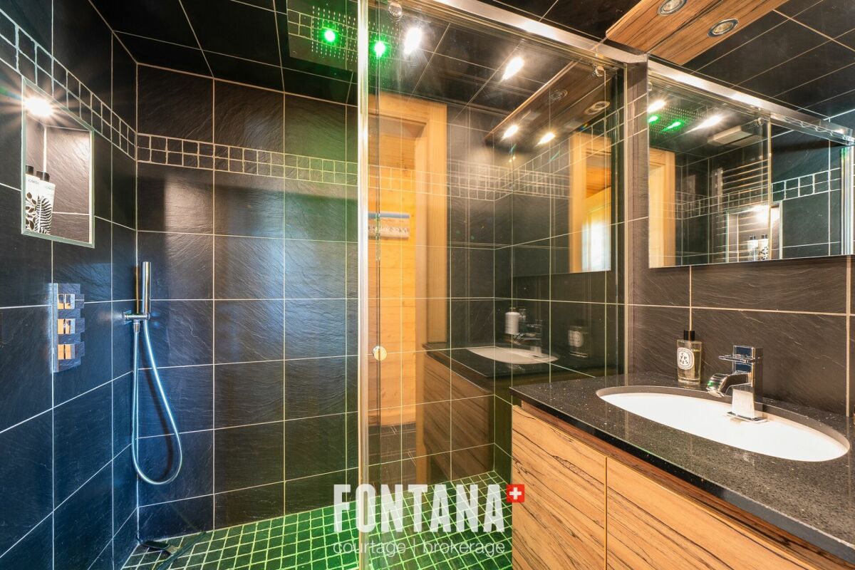 Modernes Badezimmer mit dunkler Dusche und Waschtisch