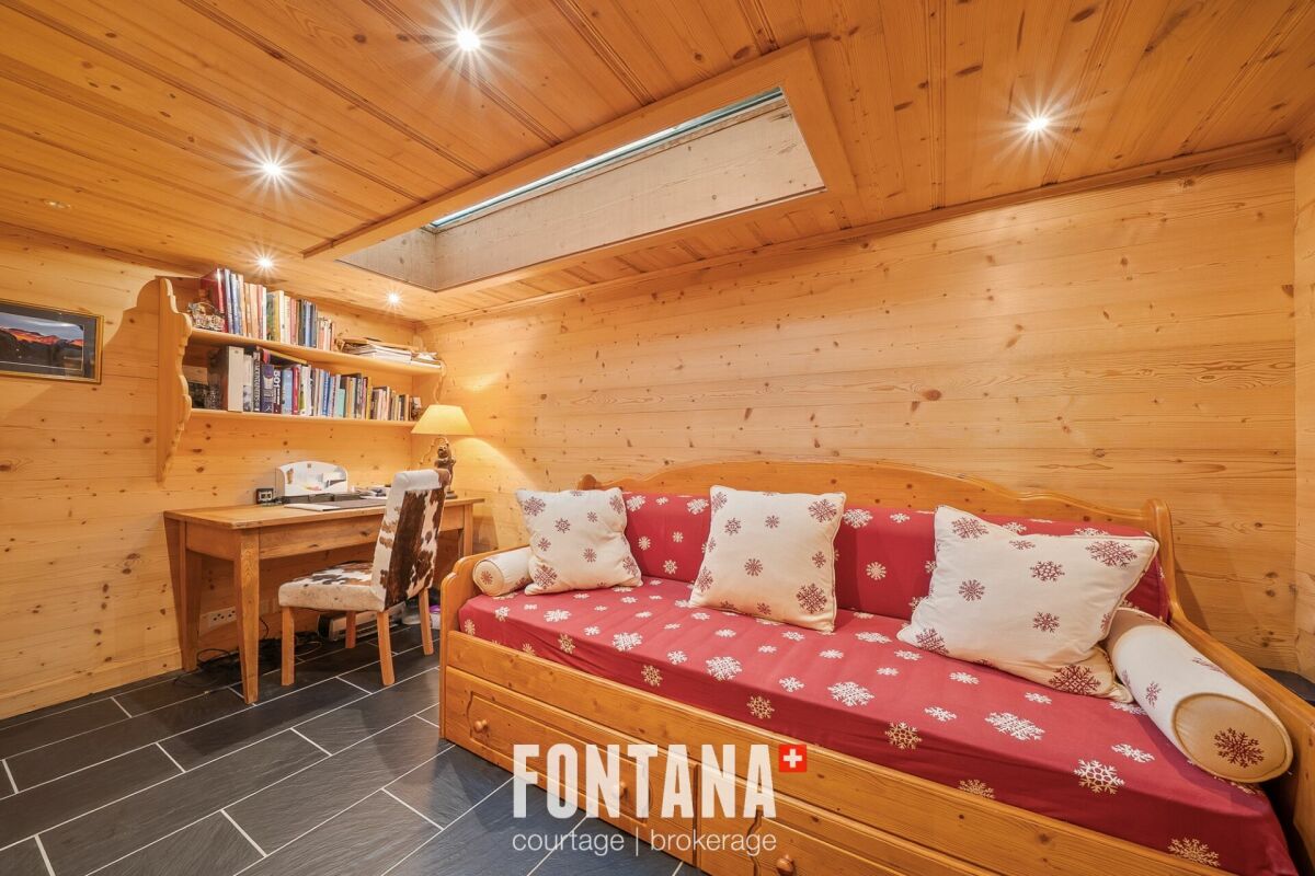 Gemütlicher Holzraum mit Schlafsofa und Schreibtisch