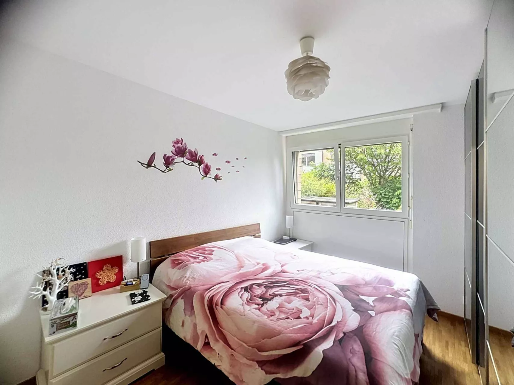 Helles Schlafzimmer mit Blumenbettwäsche