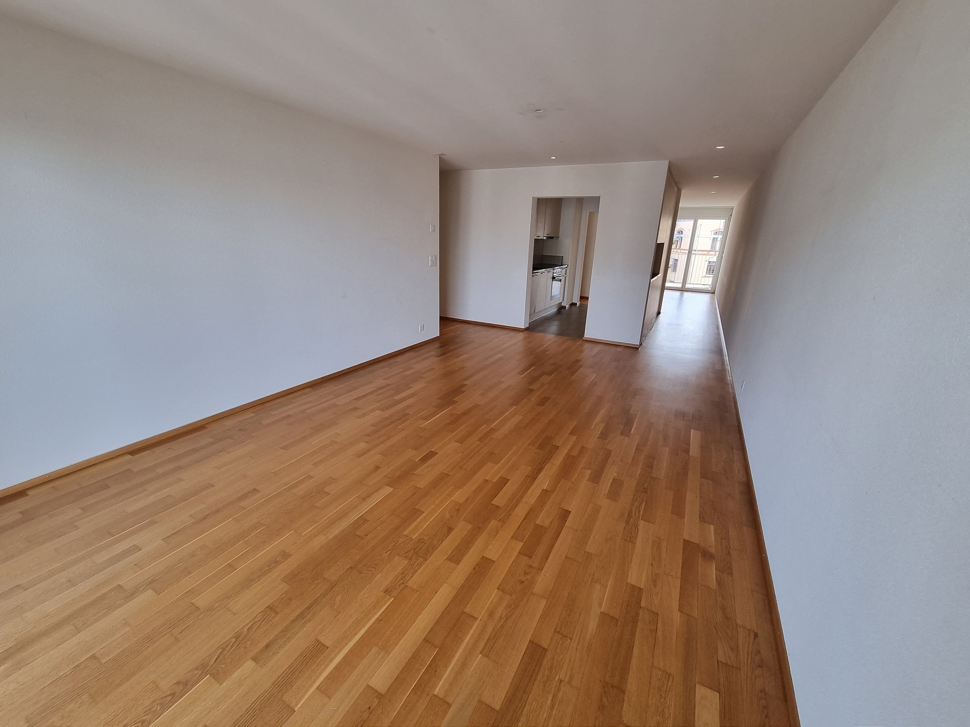 Langer leerer Wohnbereich mit Parkett