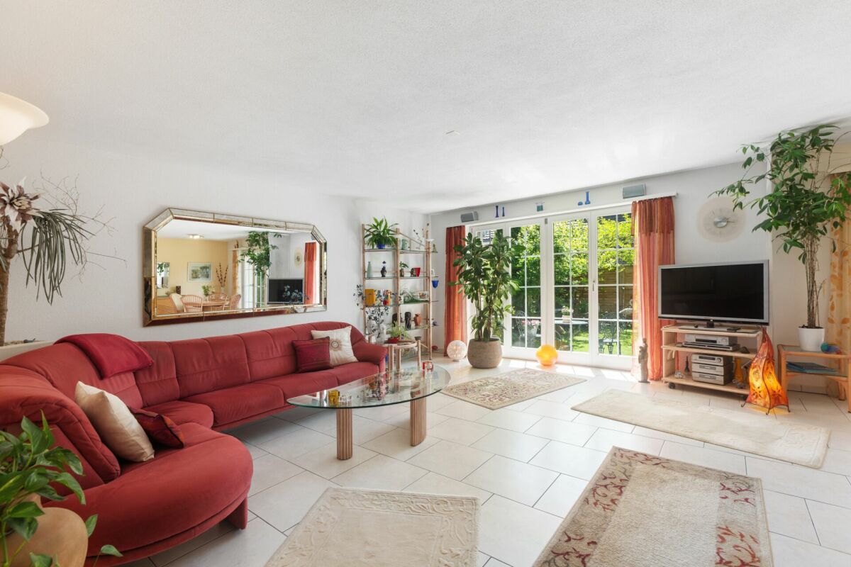 Helles Wohnzimmer mit großer Fensterfront und Gartenblick