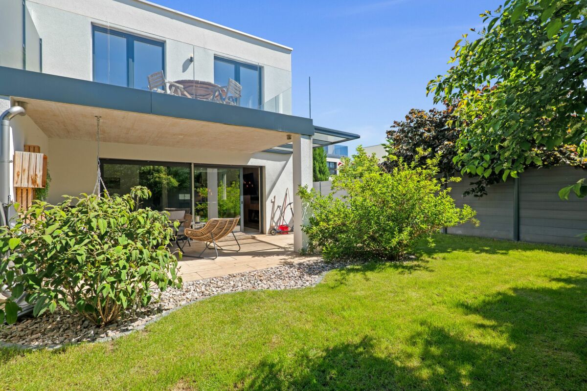 Moderner Garten mit Terrasse und Hausfassade