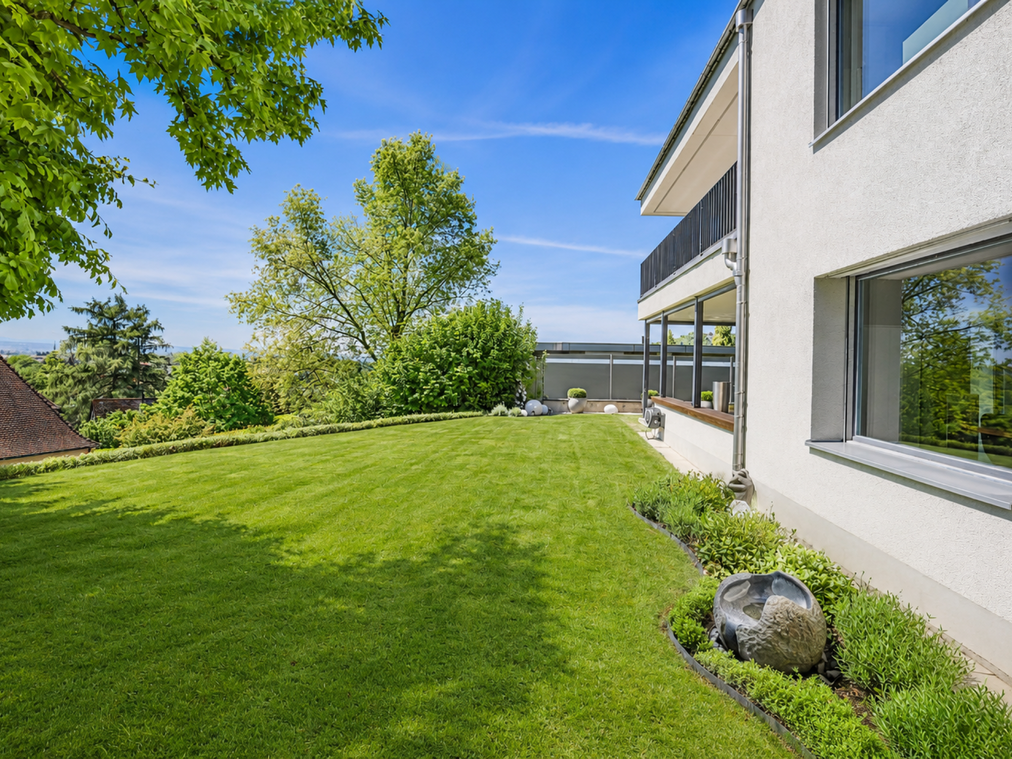 Großer Garten mit moderner Hausfassade