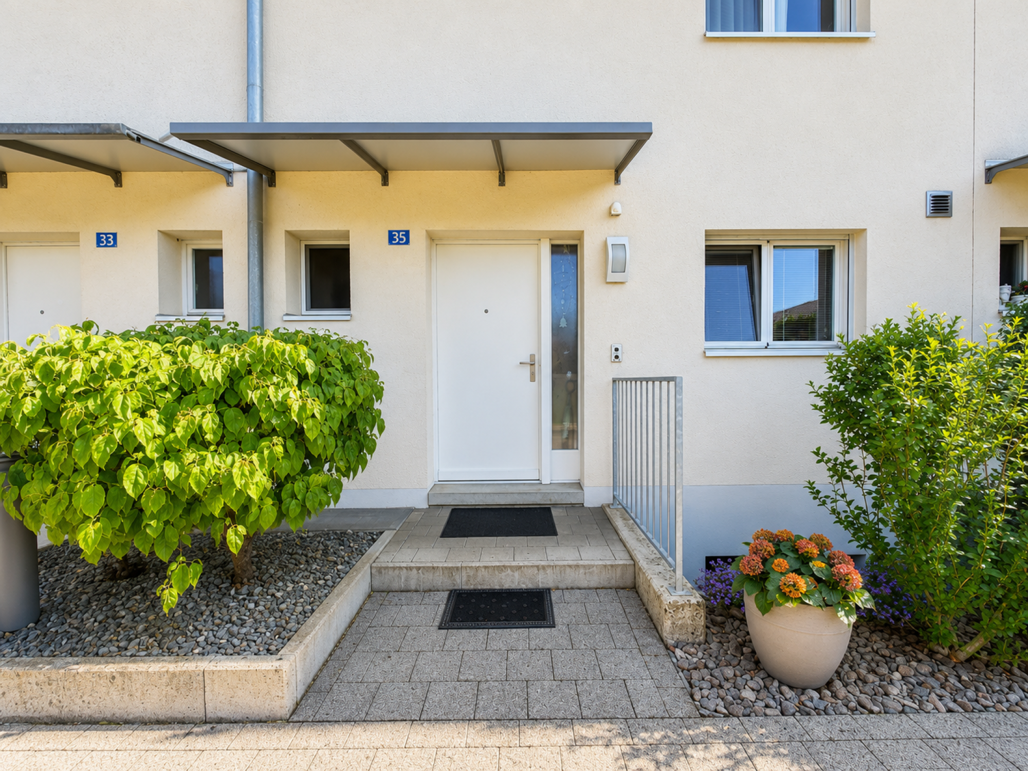 Hauszugang mit Haustür und Vorgarten